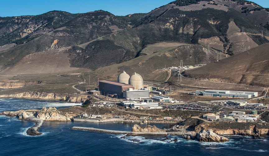 An aerial side view of a nuclear plant next to the ocean