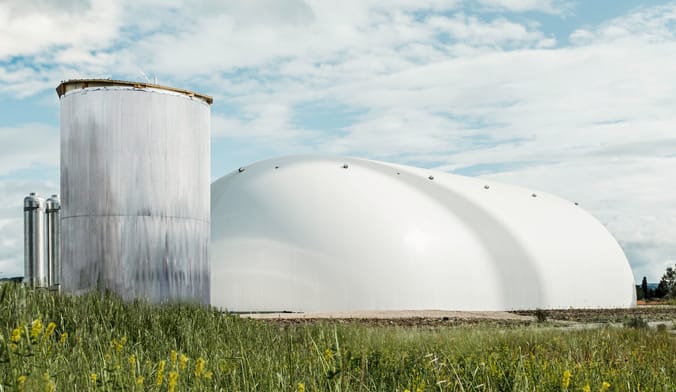 A large white industrial bubble next to a metal silo-type structure