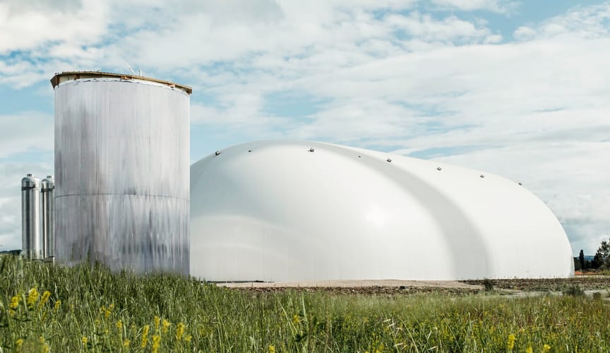 A large white industrial bubble next to a metal silo-type structure