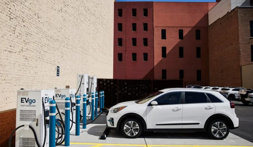 A white car charging at a bank of EVgo electric vehicle chargers