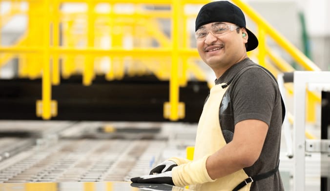 A smiling man on a factory assembly line