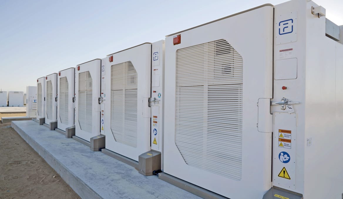 A row of white utility-scale battery units