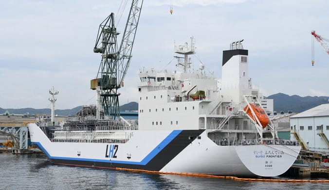 A large white ship in harbor with the letters LH2 on the side