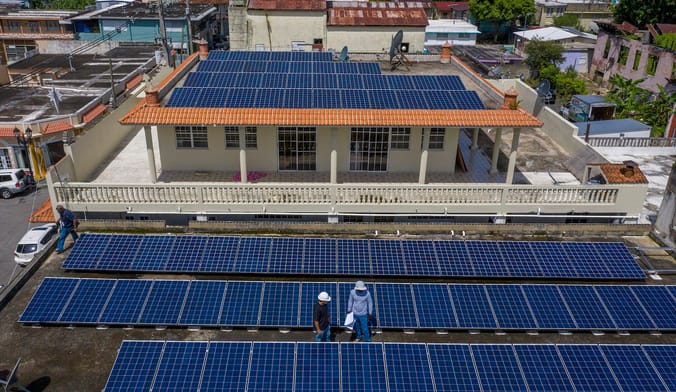 An overhead view of a Puerto Rican business establishment's roof that is covered in solar panels