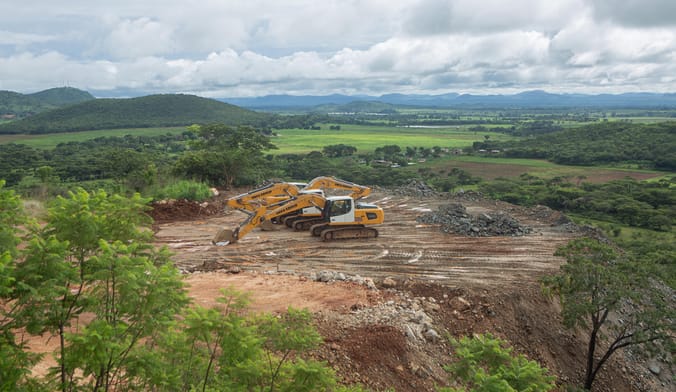 several excavators sit idle at a large lithium mine site
