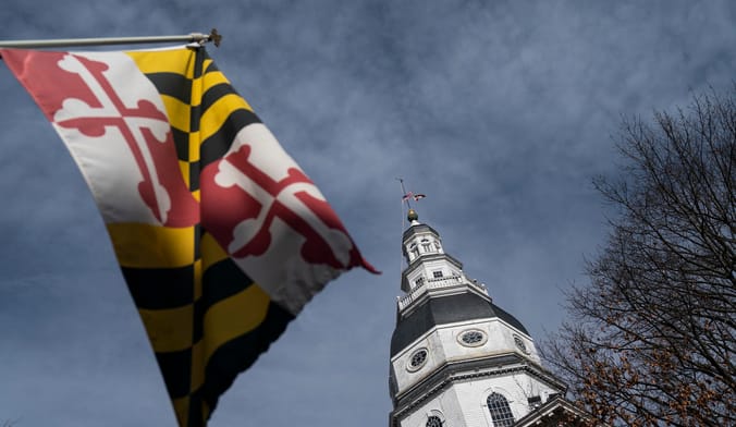 The Maryland state flag flies in front of the Maryland state legislature building