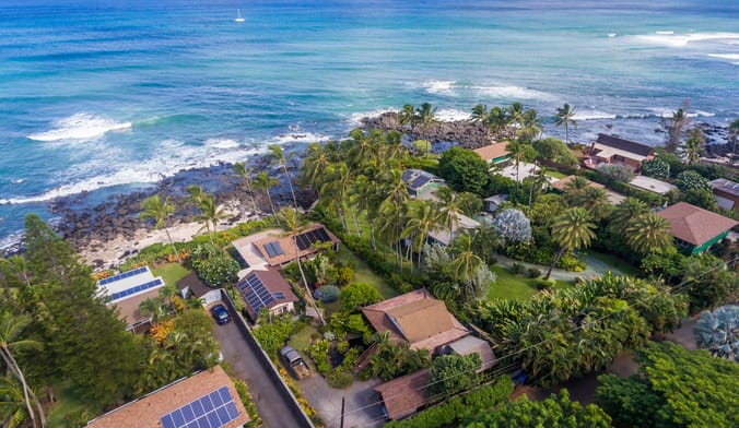 Aerial view of homes with solar panels on their roofs near the ocean in Hawaii