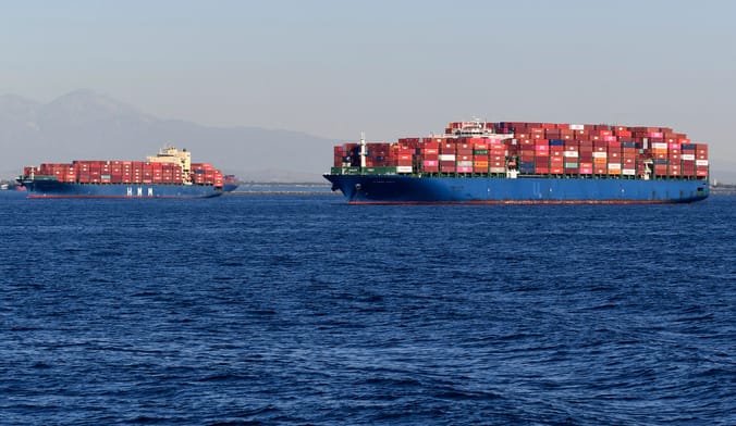 Two ships carrying many colorful cargo containers in the ocean