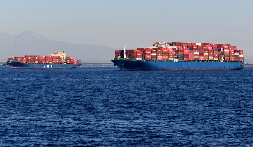 Two ships carrying many colorful cargo containers in the ocean