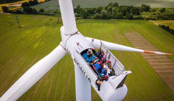 People inside the nacelle of a very tall wind turbine