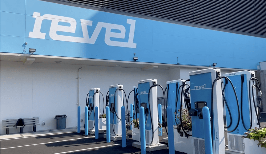 An empty parking lot with many blue EV chargers