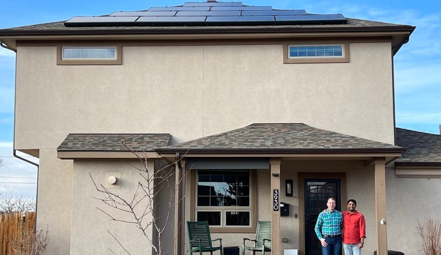 Two men in front of Denver home with solar panels on the roof.