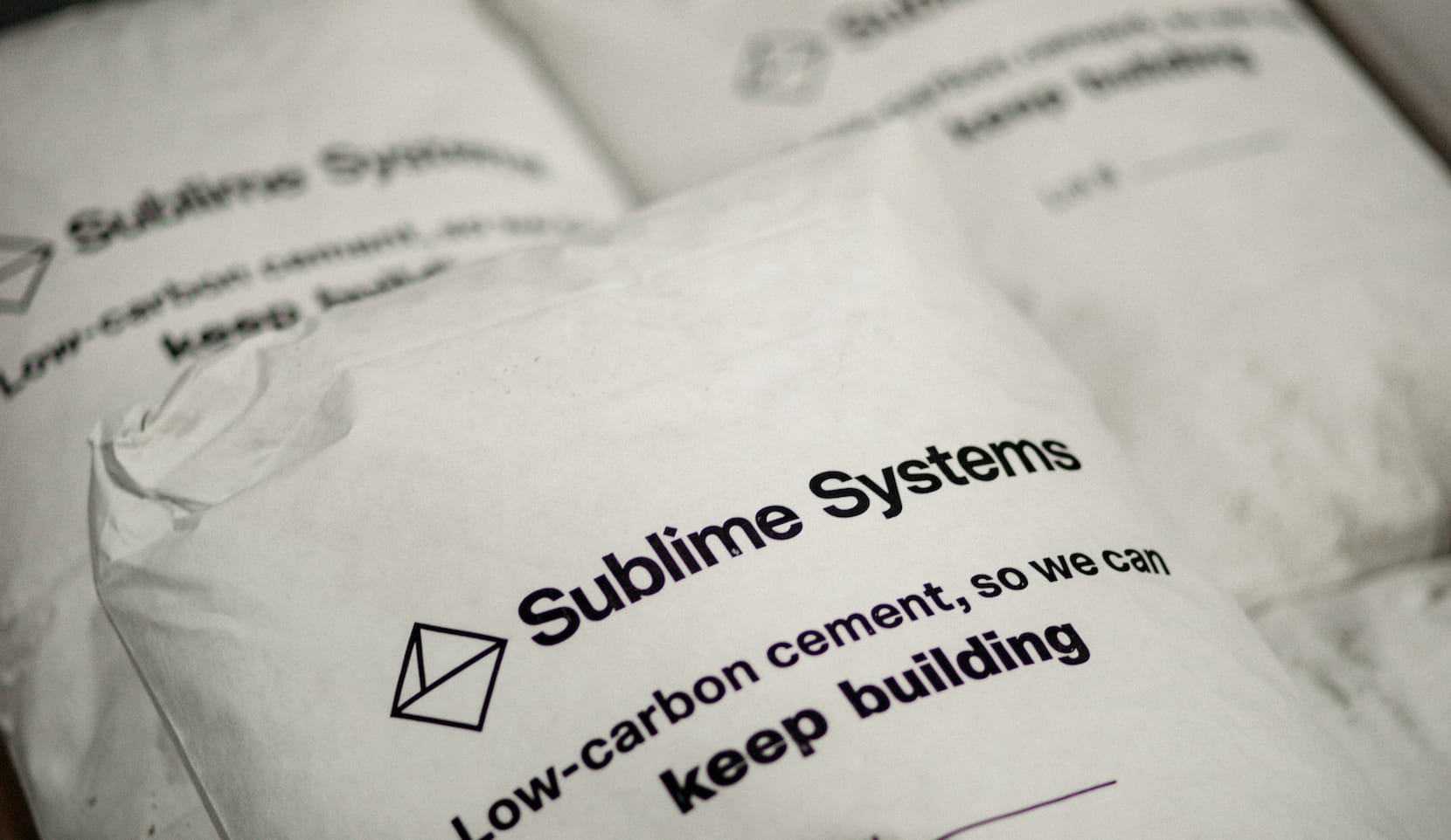 White bags of cement materials printed with the words Sublime Systems Low-carbon cement, so we can keep building