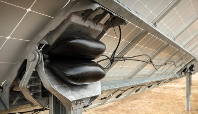 Two small, black inflated bags attached to the back side of a solar panel