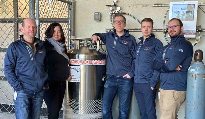 Five workers around a CO2 tank