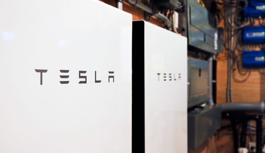 Two Tesla Powerwall batteries on a garage wall