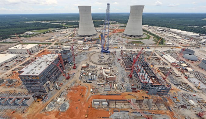Aerial view of large industrial facility including two nuclear cooling stacks