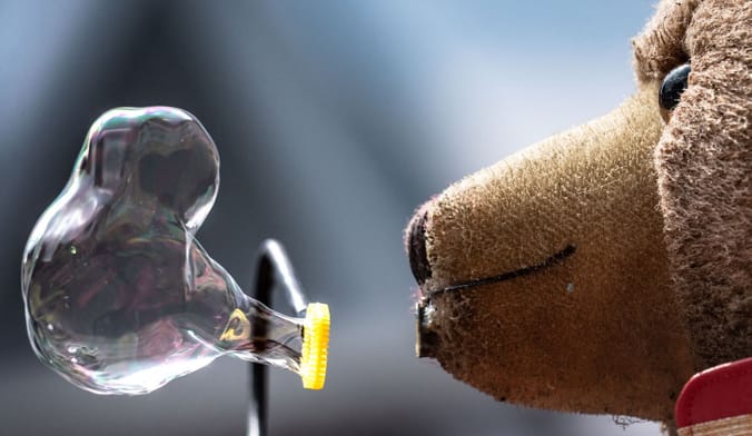 A teddy bear blowing bubbles