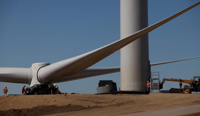 A large rotor is prepared for installation onto a wind turbine generator